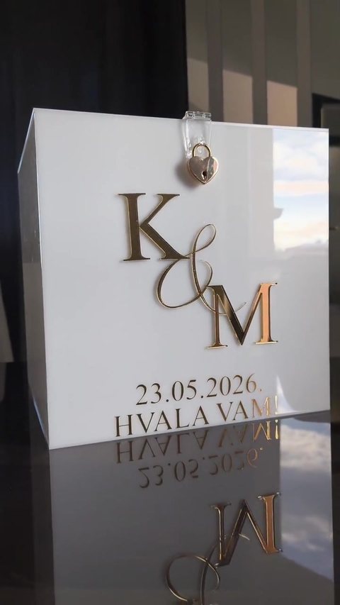 Video: bijela akrilna kutija za kuverte sa zlatnim 3D slovima K&M, datumom 23. 5. 2026. i natpisom „Hvala vam“.